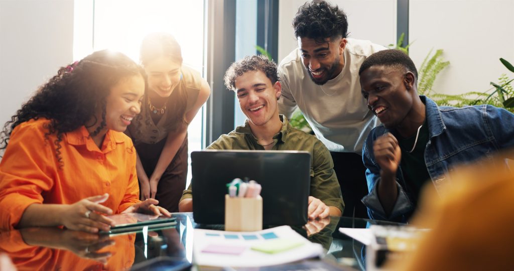 Creative team collaborating around a laptop